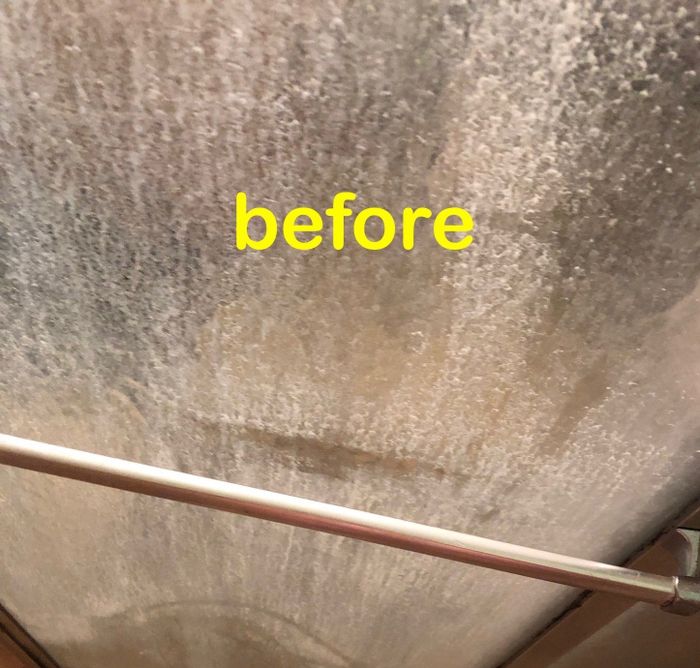 Reviewer's before photo of a shower door clouded with hard water stains