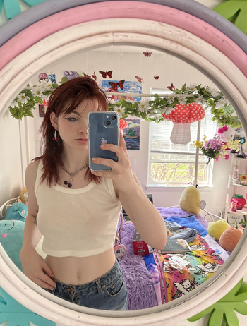 A reviewer's selfie in the mirror with the lantern visible through the reflection in the window