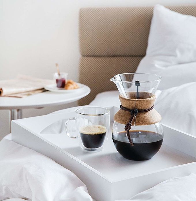 A glass pour-over coffee maker with a cork band wrapped around the middle, adding a touch of style.
