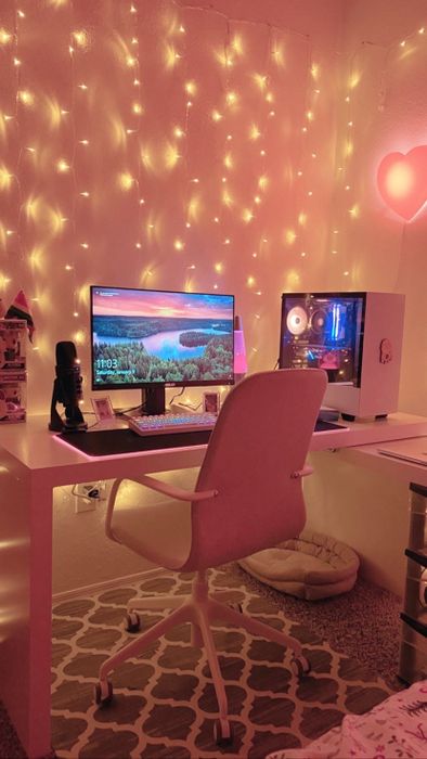 Fairy lights strung across a pink desk setup, adding a soft glow to the space