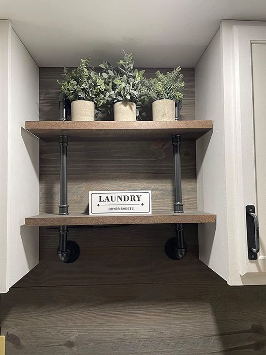 Three artificial plants arranged on a shelf in a laundry room