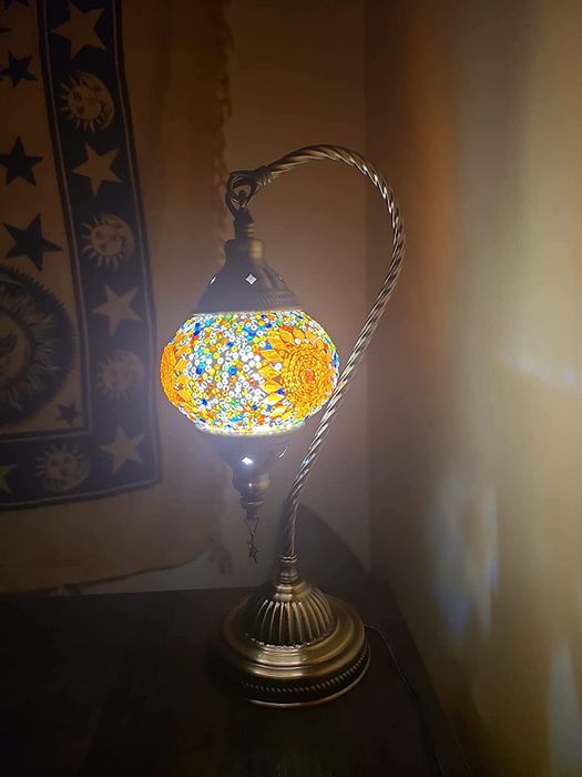 A lamp on a nightstand emitting a warm yellow glow
