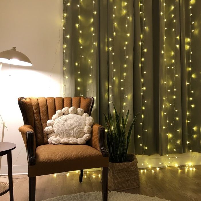 The lights gracefully hanging against the backdrop of window curtains