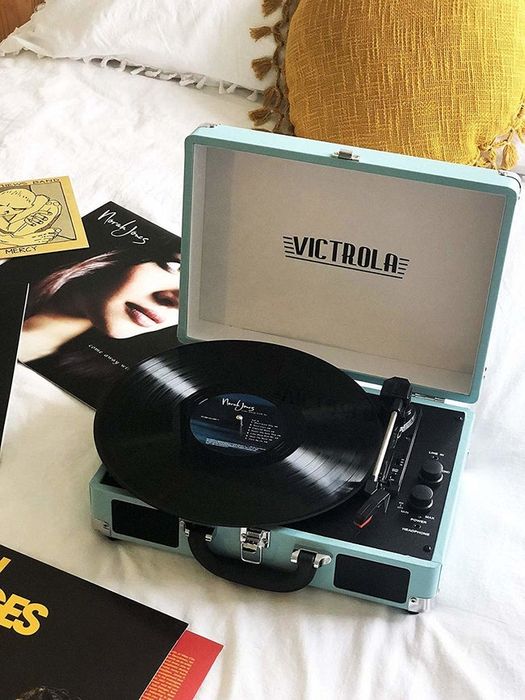 A light blue record player with a Norah Jones album on display, adding a nostalgic touch to the room
