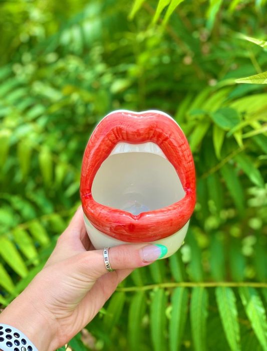 A person holding up the lips-shaped planter