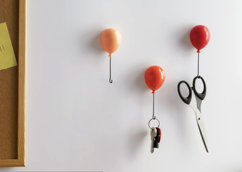 three small balloon-shaped hooks in shades of red, holding keys and scissors