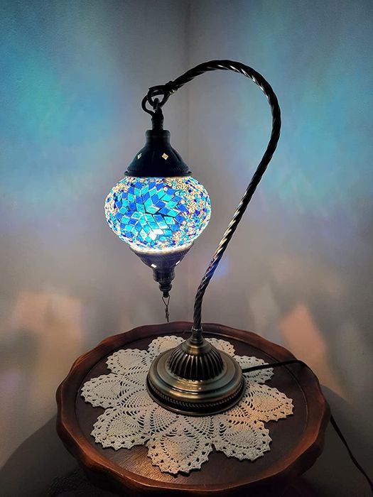 A lamp on a round table casting a cool blue light