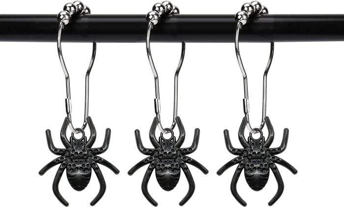 Three silver spider-shaped earrings hanging from hooks, intricately designed with small decorative details. The image is part of a shopping article