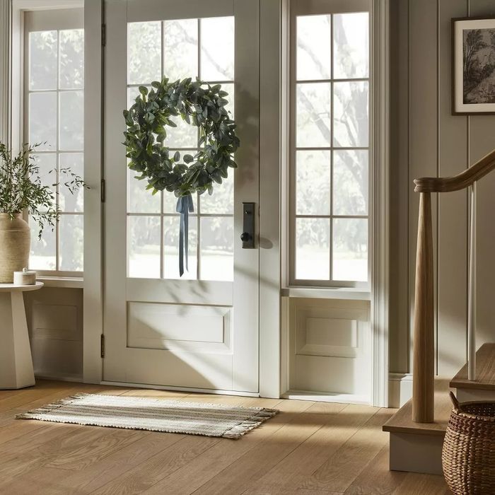 A faux wreath hanging on a door, adding a welcoming touch.