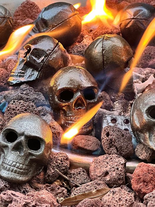 Metal skull decorations placed among lava rocks with flames, perfect for Halloween-themed outdoor setups
