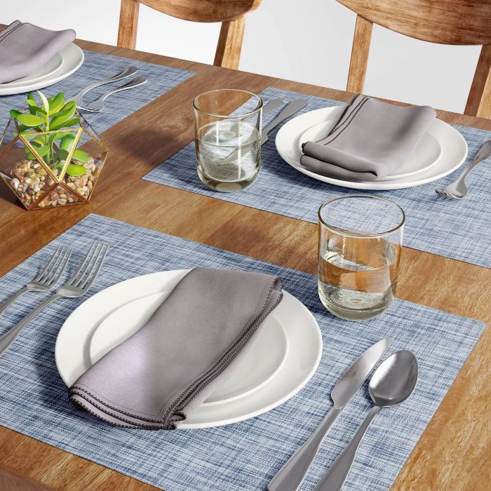 Blue placemats placed on a table under two dinner settings
