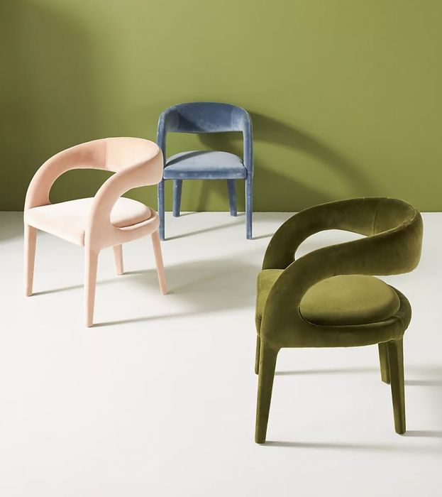 A blue chair, a pink chair, and a green chair scattered across the room