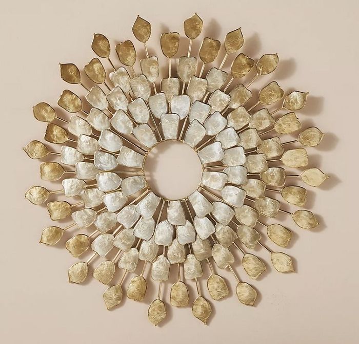 The sculpture gracefully hanging on the wall above a chair, casting its radiant glow.