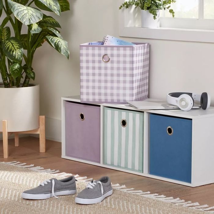 The lavender gingham storage bin placed on top of a cubby unit