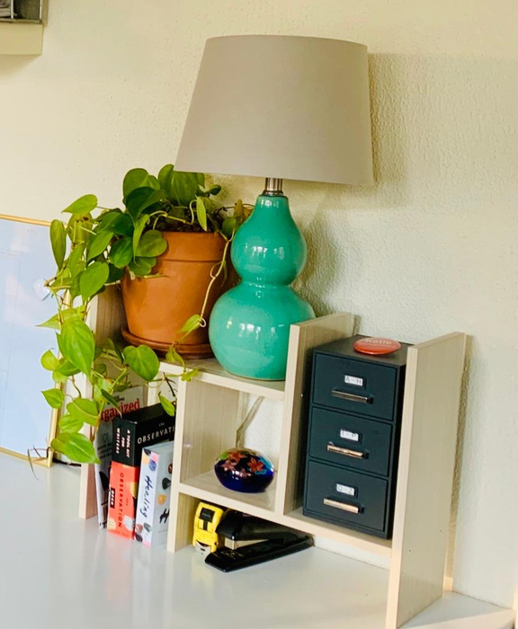A reviewer’s white wood shelves neatly organizing desk items