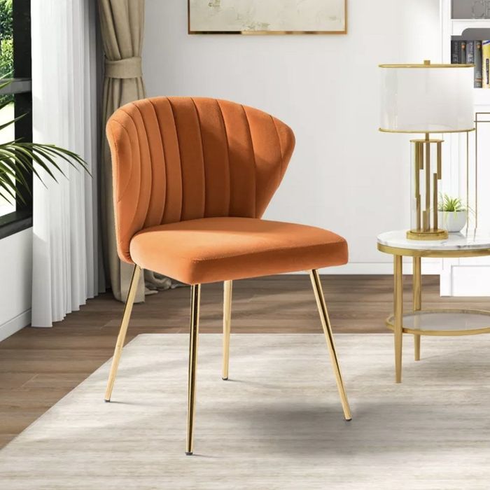 An orange velvet accent chair