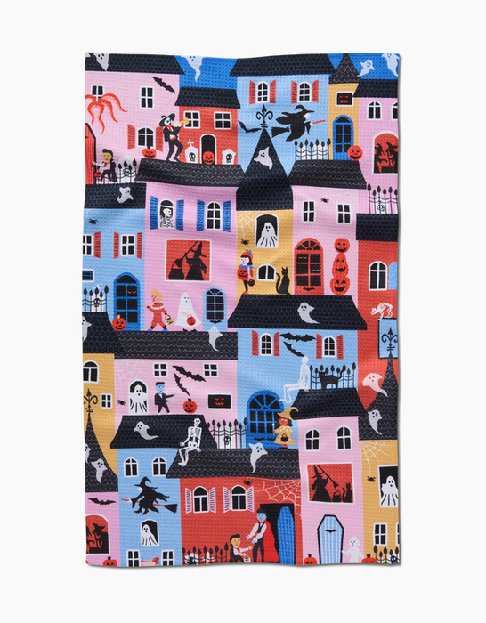A Halloween-inspired blanket featuring vibrant designs of haunted houses, ghosts, pumpkins, witches, and trick-or-treaters