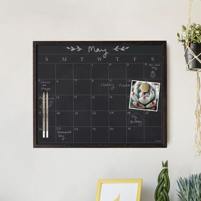 The calendar with its chalk pencils hanging on a wall, adding an elegant touch to any space.