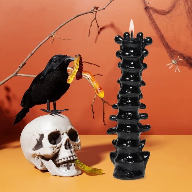 the spine-shaped candle featuring a faux skull and raven