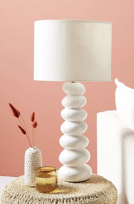The lamp resting on a nightstand, accompanied by a glass of water and a ceramic diffuser.