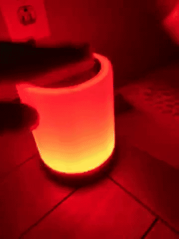 A reviewer tapping the lamp to cycle through its different color settings.