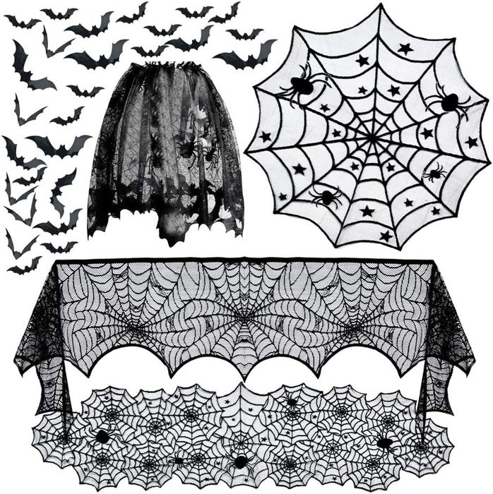 Halloween decorations featuring a bat-patterned skirt, a spider web tablecloth, and lace spider web and black bat wall accents