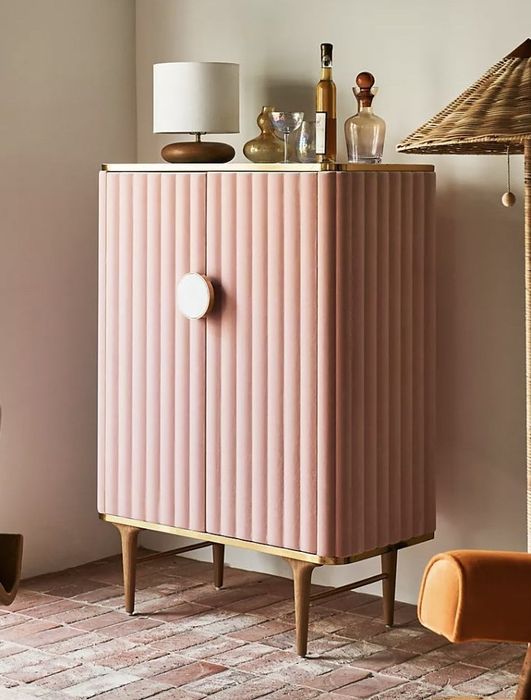 The pink cabinet tucked into the corner of the room, neatly shut.
