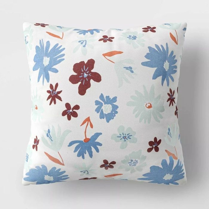 The pillow with a floral design in blue, maroon, and orange hues