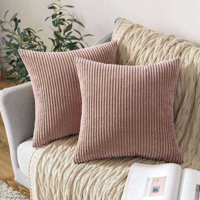 Two blush pink corduroy covers placed on throw pillows.