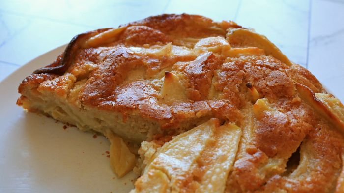 A plate featuring a freshly baked French apple cake.