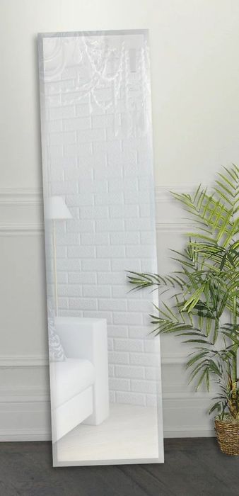 A full-length mirror leaning against the floor