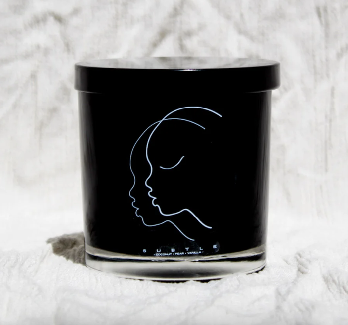 A black candle with a white face vignette is shown.
