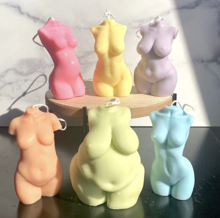 A variety of candles in the shape of female body forms in different sizes and pastel colors.
