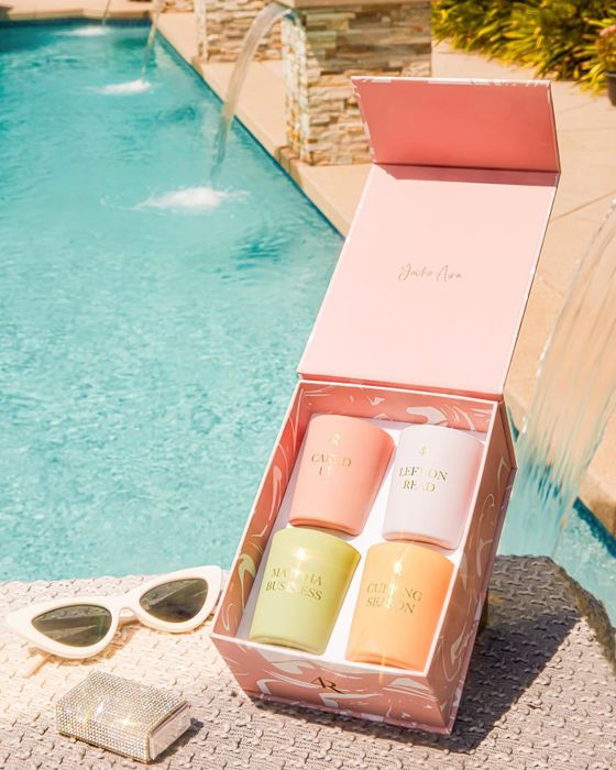A set of candles rests beside a pool in a stylish setting.