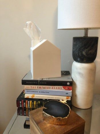 The tissue box covers placed atop a stack of books.