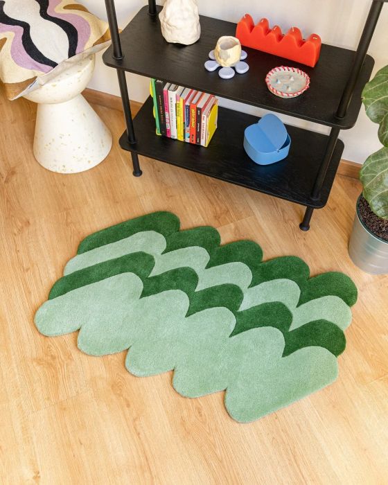 A rug with an intriguing design of squiggly lines in shades of light and dark green, bringing a dynamic and organic flow to your space.