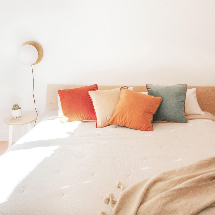 The velvet color-block pillow covers placed atop a bed, adding a bold touch of color.