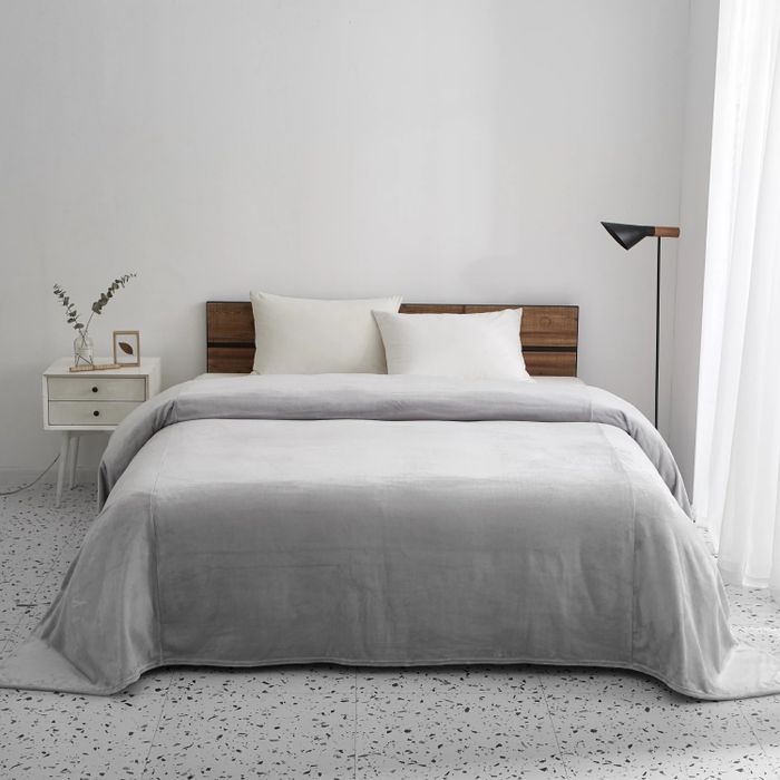 A cozy fleece blanket laid out on a bed in a bedroom