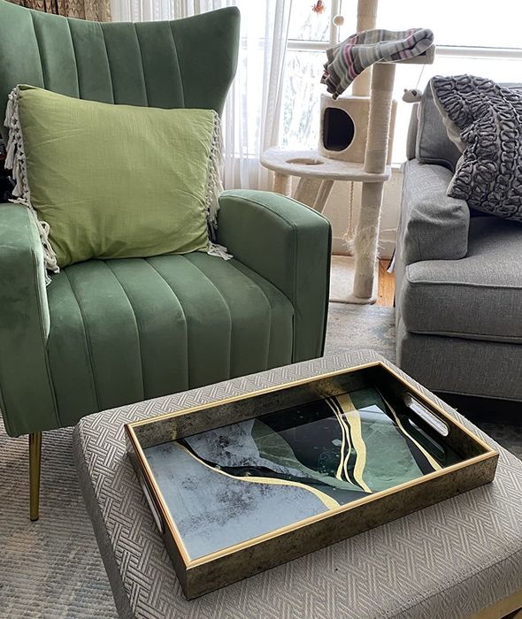 A reviewer’s photo of the green and gold serving tray placed on a living room table.
