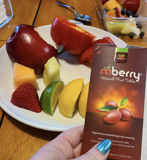 reviewer holding the package with the fruit visible behind it