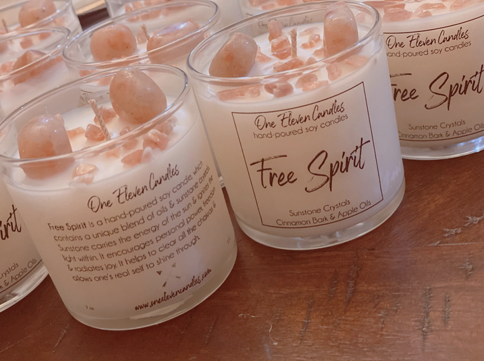 A display of candles with crystals embedded in the wax is shown.