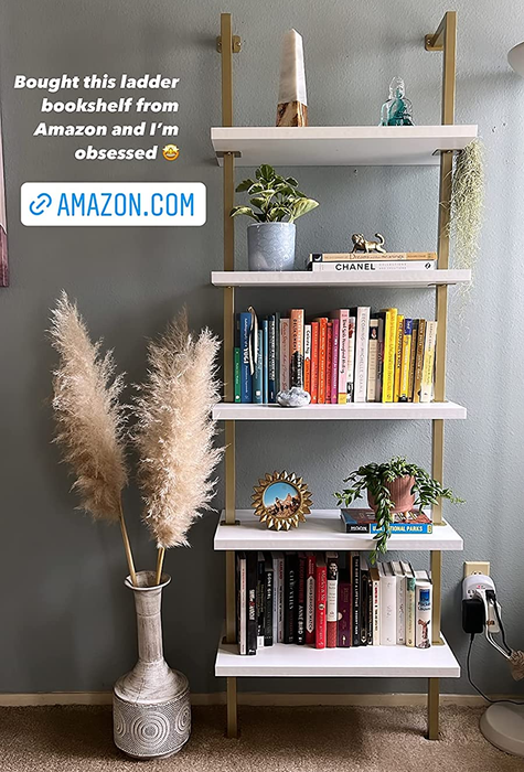 Reviewer photo of a chic white and gold bookshelf featuring an uplifting quote.