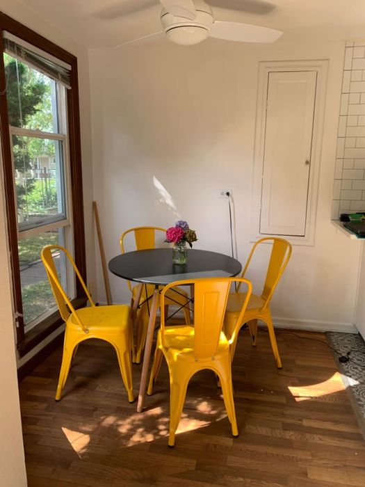 A reviewer’s vibrant dining setup featuring a round table and four yellow chairs in a sunlit room, ideal for home decor inspiration.