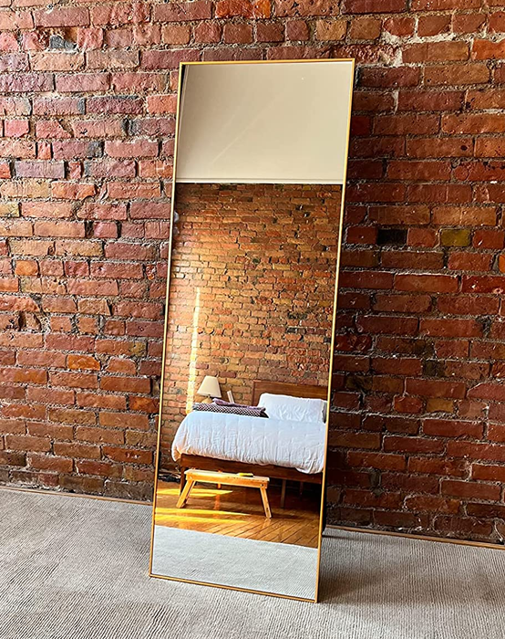 Another reviewer highlights the gold-framed mirror leaning beautifully against a brick wall in their bedroom, enhancing the room's character.