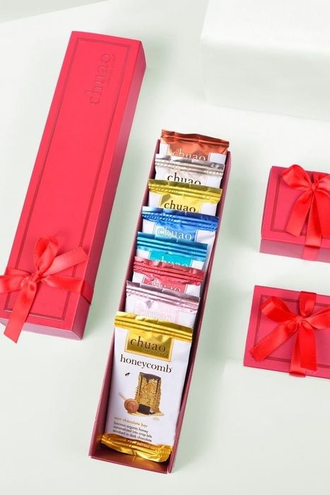 A selection of mini chocolate bars inside a rectangular box, tied with a ribbon