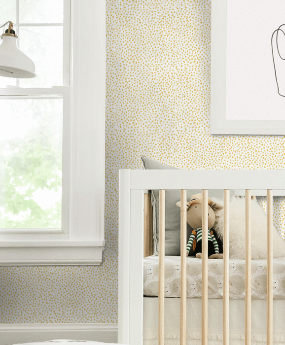Yellow speckled wallpaper installed in a nursery.