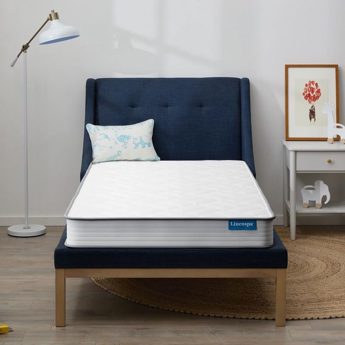 A white mattress set up in a cozy bedroom