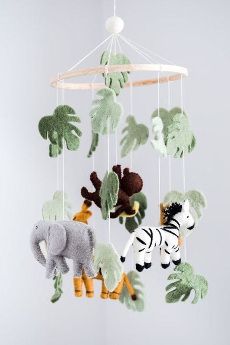 A mobile featuring felt animals is displayed