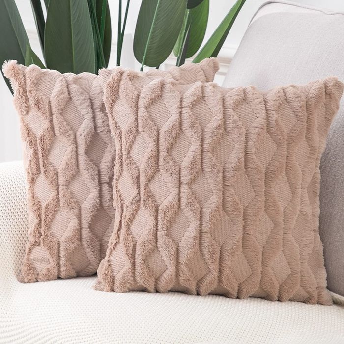 Two light pink pillows placed on a sofa