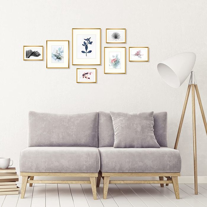 The frames arranged on a wall behind a sofa